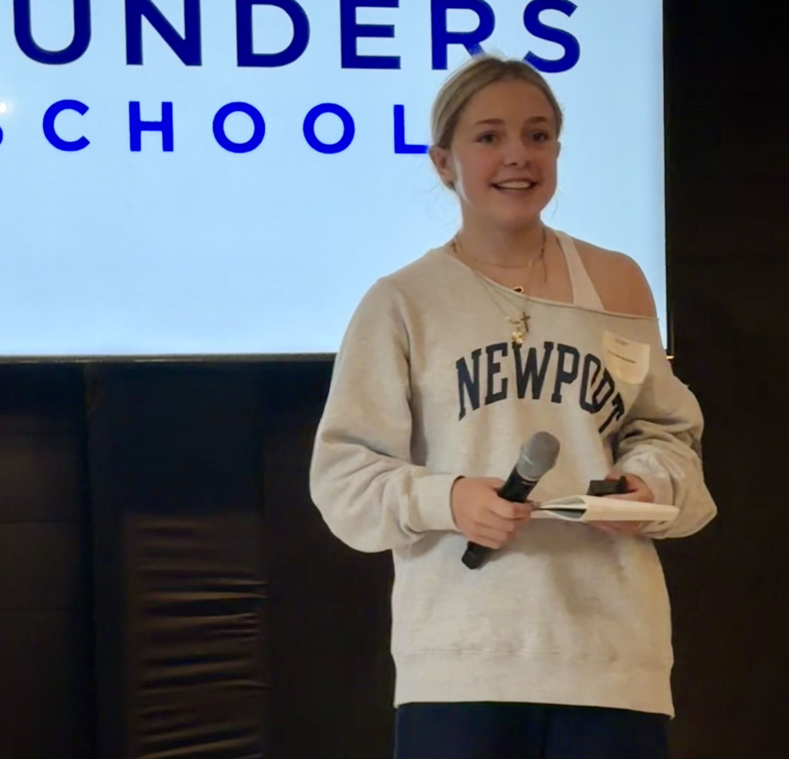 Charlotte Kezirian holding a microphone during a presentation